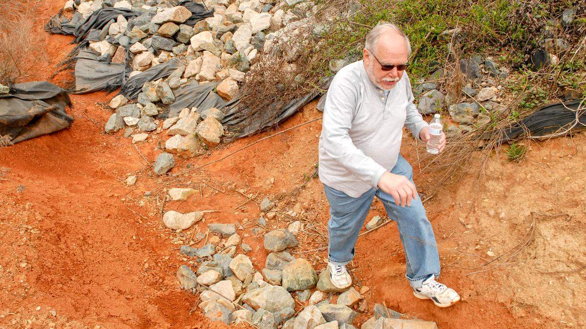 Marshall Dietz checks the spillway near the dam in his Cary neighborhood.