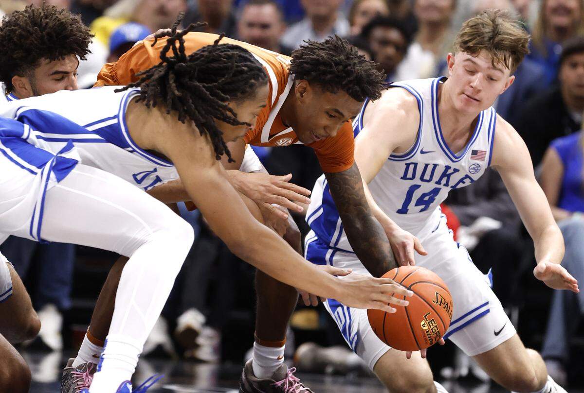 Duke’s Maliq Brown (6) and Nikolas Khamenia (14) go after the loose ball with Texas' Dailyn Swain (3) during the first half of Duke’s game against Texas in the Dick Vitale Invitational at the Spectrum Center in Charlotte, N.C., Tuesday, Nov. 4, 2025.