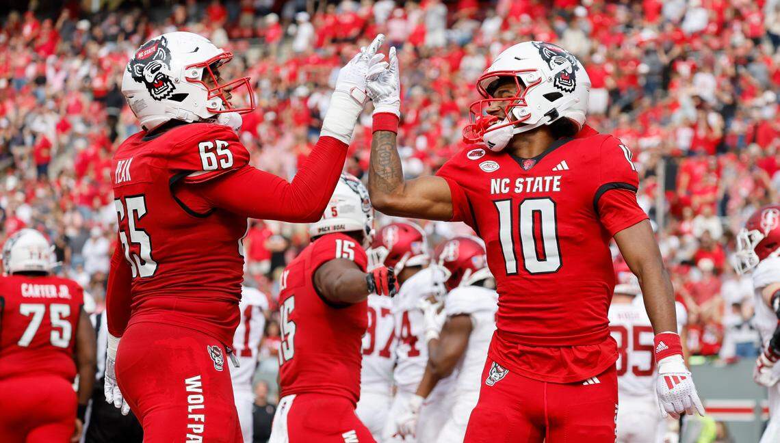 N.C. State offensive tackle Jacarrius Peak (65) celebrates with wide receiver KC Concepcion (10) after Concepcion scored on a touchdown run during the second half of N.C. State’s 59-28 victory over Stanford at Carter-Finley Stadium in Raleigh, N.C., Saturday, Nov. 2, 2024.