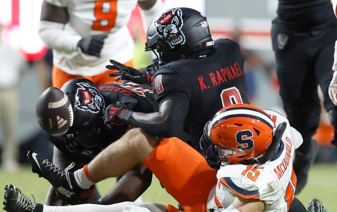 N.C. State running back Kendrick Raphael (0) fumbles the ball while being hit by Syracuse linebacker Derek McDonald (15) during the first half of N.C. State’s game against Syracuse at Carter-Finley Stadium in Raleigh, N.C., Saturday, Oct. 12, 2024. Syracuse would recover the fumble.
