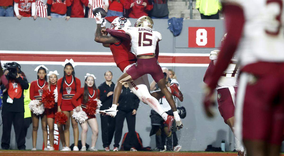 With 1:47 left in the game, N.C. State’s Justin Joly (7) pulls in a 12-yard touchdown reception as Florida State’s Shamar Arnoux (15) defends during the second half of N.C. State’s 21-11 victory over Florida State at Carter-Finley Stadium in Raleigh, N.C., Friday, Nov. 21, 2025.
