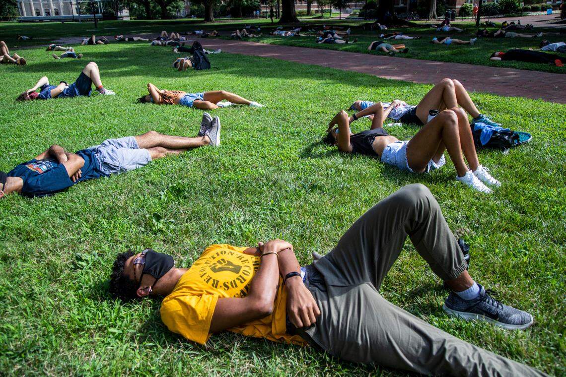Demonstrators participate in a “die in” outside the South Building at UNC-Chapel Hill while protesting the university’s decision to hold in-person classes amid the coronavirus pandemic Tuesday, August 5, 2020.