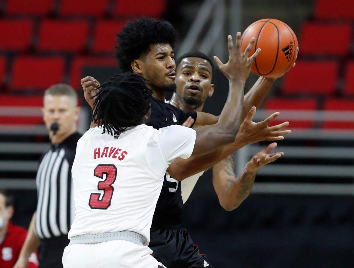 N.C. State’s Cam Hayes (3) and Thomas Allen (5) pressure Miami’s Harlond Beverly (5) during the first half of N.C. State’s game against Miami at PNC Arena in Raleigh, N.C., Saturday, January 9, 2021.