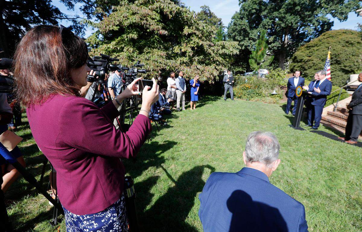 News & Observer politics reporter Dawn Vaughan, left, reporting at the Executive Mansion on Sept. 1, 2022, as N.C. Gov. Roy Cooper presents former Duke men’s basketball head coach Mike Krzyzewski with The Order of the Long Leaf Pine award.