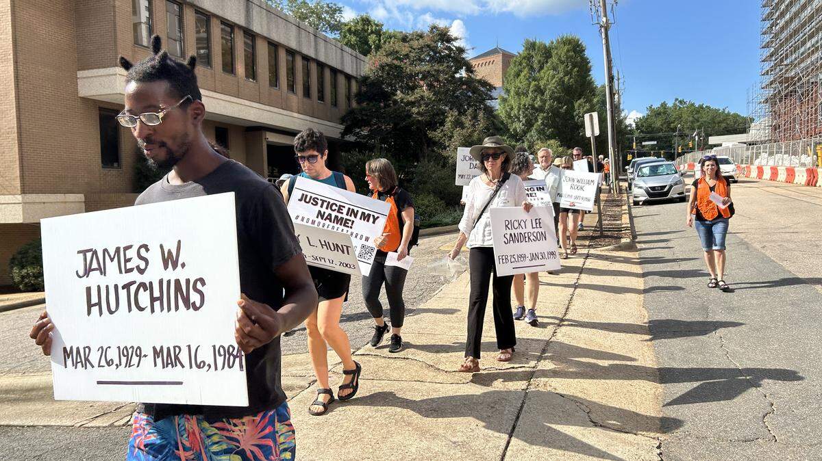 Protesters hold signs bearing the names of people executed by North Carolina as they marched to Central Prison in Raleigh, N..C., on Aug. 16, 2025 in an event organized by the N.C. Coalition for Alternatives to the Death Penalty.