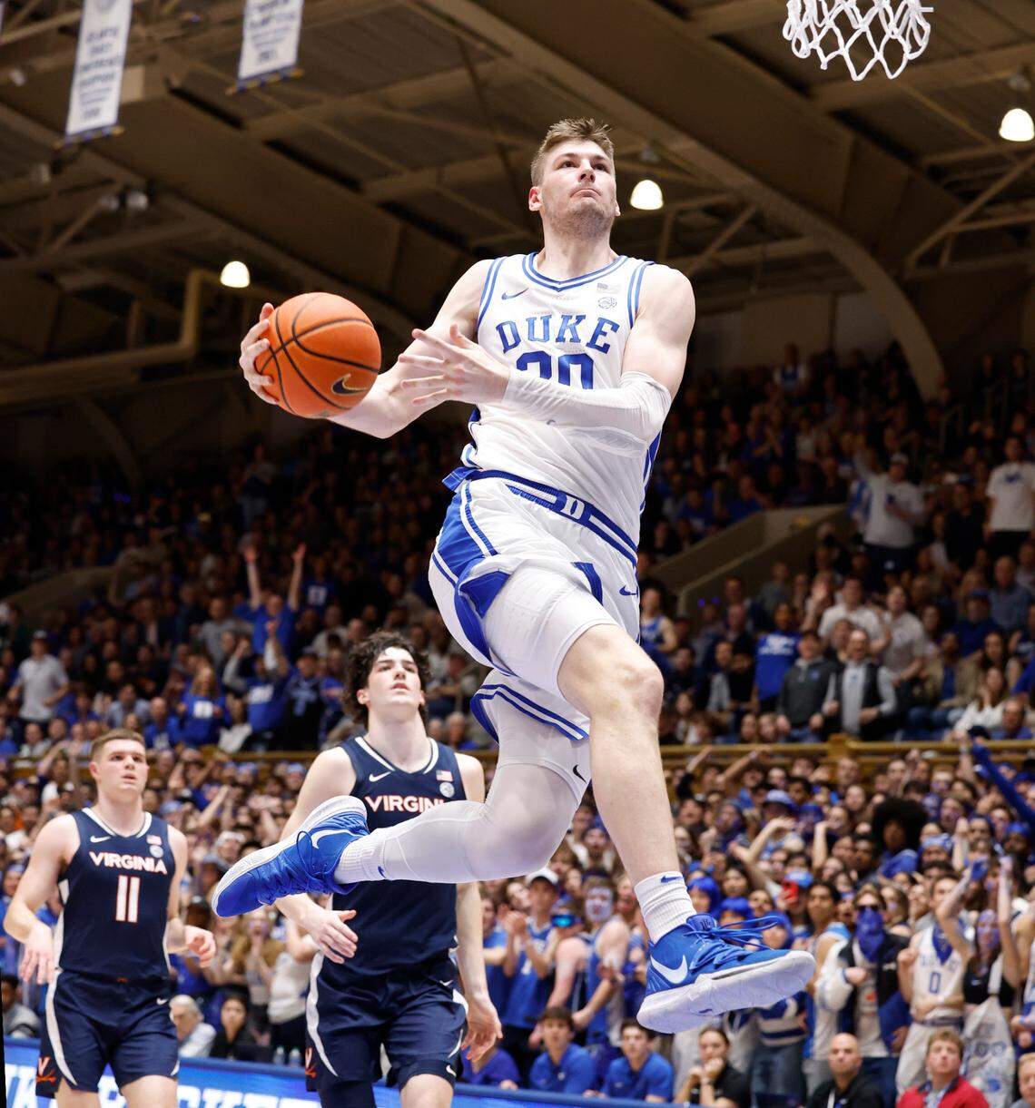 Duke’s Kyle Filipowski (30) heads in to slam in two with a windmill dunk during the first half of Duke’s game against Virginia at Cameron Indoor Stadium in Durham, N.C., Saturday, March 2, 2024.