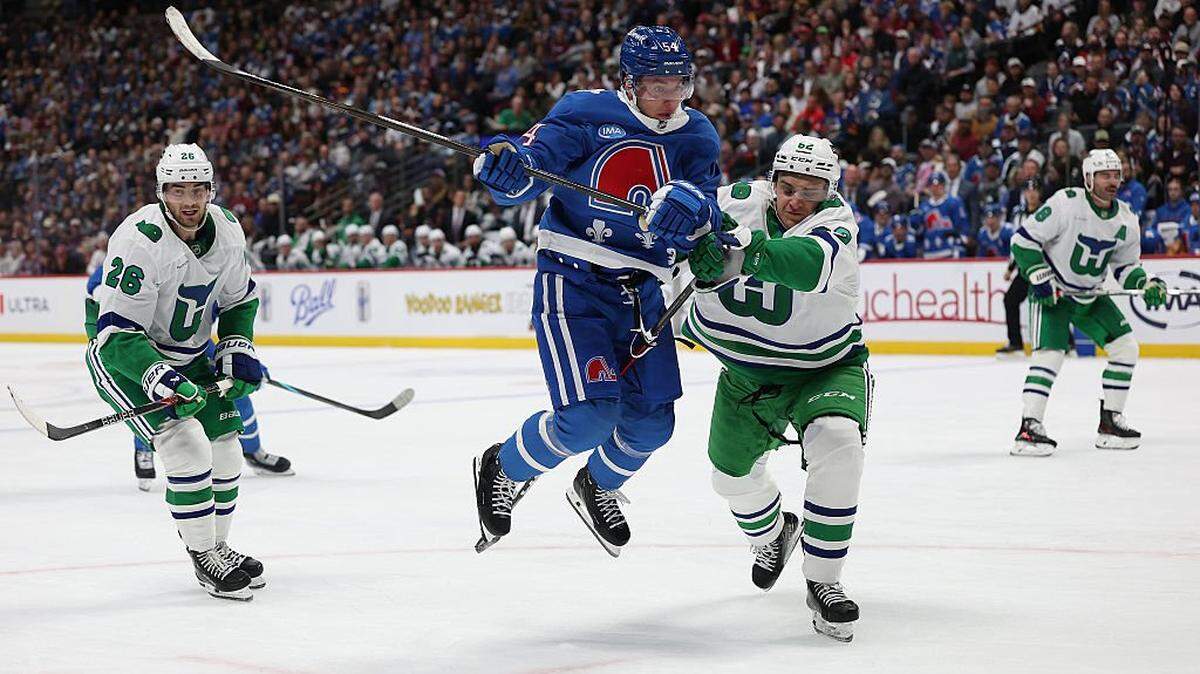 Gavin Brindley (54) of the Colorado Avalanche fights for the puck against Charles-Alexis Legault (62) of the Carolina Hurricanes in the second period at Ball Arena on October 23, 2025 in Denver, Colorado.