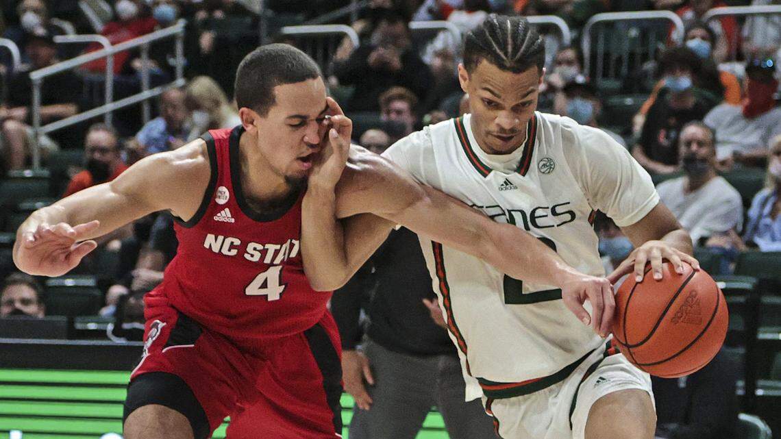 Miami Hurricanes guard Isaiah Wong (2) battles North Carolina State Wolfpack forward Jericole Hellems (4) at the Watsco Center in Coral Gables on Wednesday, December 29, 2021.