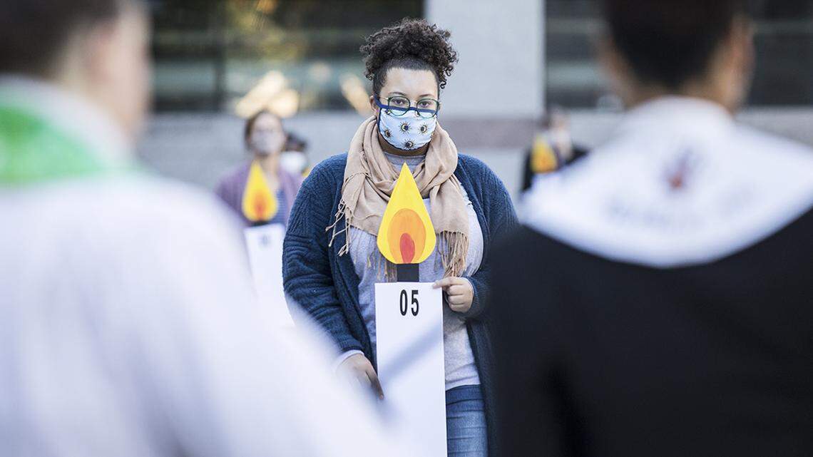 Naomi Hodges carries a candle poster representing the year 2005, one year in the 28-year-long Leandro court case, during a prayer vigil held by Pastors for NC Children in Raleigh, N.C. on Monday, Oct. 18, 2021.