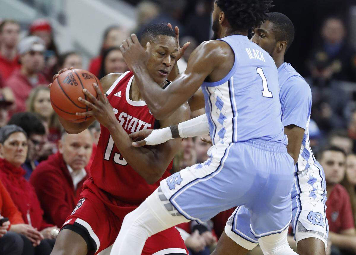 North Carolina’s Leaky Black (1) and Brandon Robinson (4) pressure N.C. State’s C.J. Bryce (13) during the first half of N.C. State’s game against UNC at PNC Arena in Raleigh, N.C., Monday, Jan. 27, 2020.