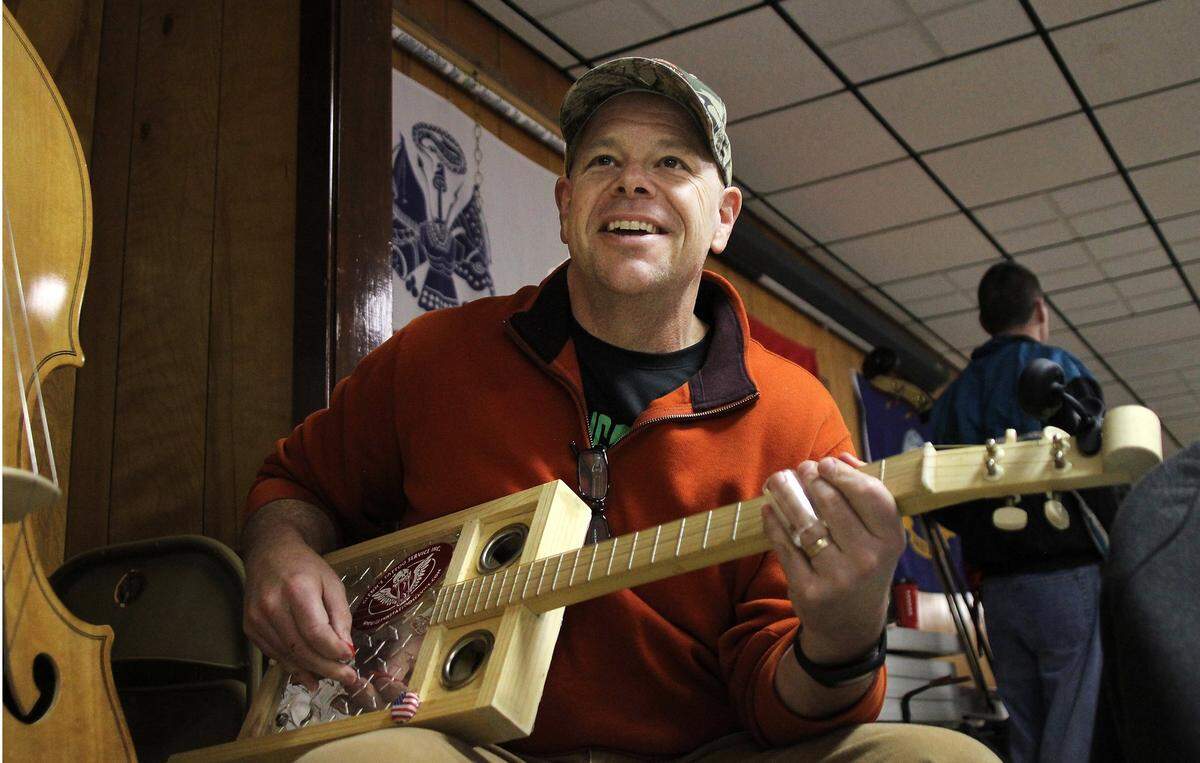 Chapel Hill Police Chief Chris Blue plays the cigar box guitar during the annual Marathon Jam at American Legion Post 6 on Saturday, Feb. 27, 2016. The 12-hour bluegrass jam session raises money for Fisher House at Fort Bragg, providing free lodging to soldiers and their families when soldiers are receiving nearby medical care.