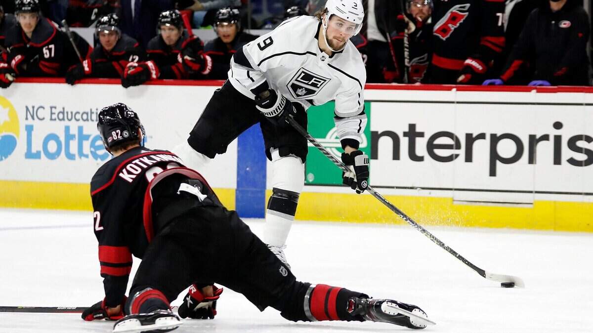 Los Angeles Kings’ Adrian Kempe (9) looks to shoot the puck over a sliding Carolina Hurricanes’ Jesperi Kotkaniemi (82) during the third period of an NHL hockey game in Raleigh, N.C., Saturday, Dec. 18, 2021. (AP Photo/Karl B DeBlaker)