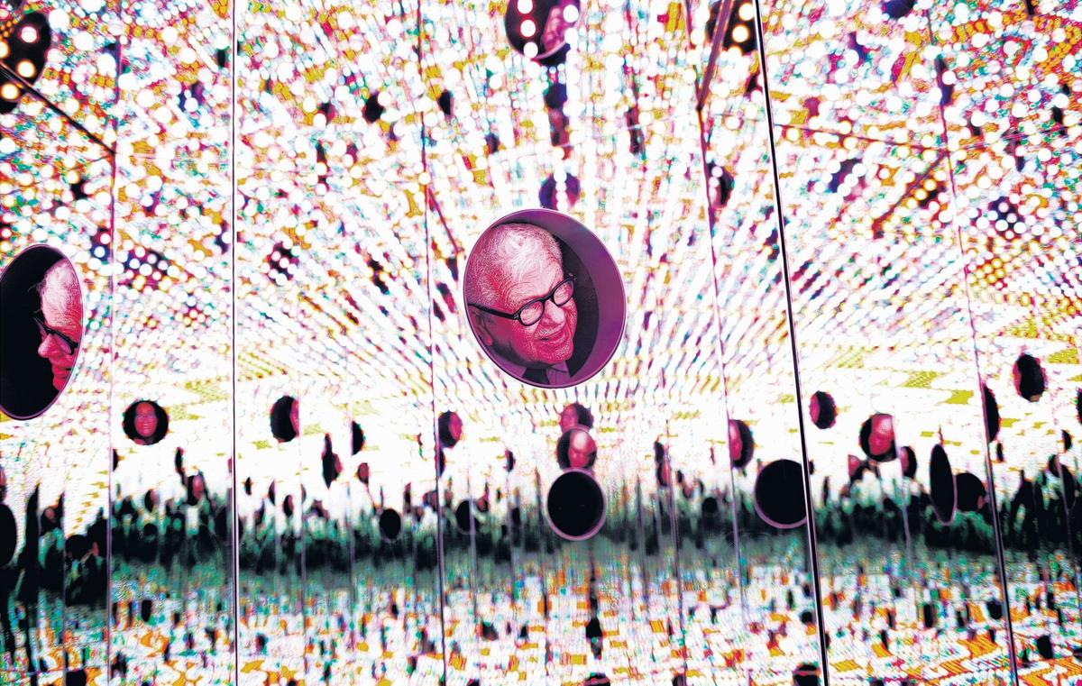 Larry Wheeler, former director of the North Carolina Museum of Art, sticks his head inside Yayoi Kusama’s “Light of Life” in 2018, one of the museum’s acquisitions. From the outside, the piece looks like a mirrored hexagonal box but stick your head inside one of its three portholes, and you’ll see yourself transported into an enclosed “infinity room” of changing colors and patterns.