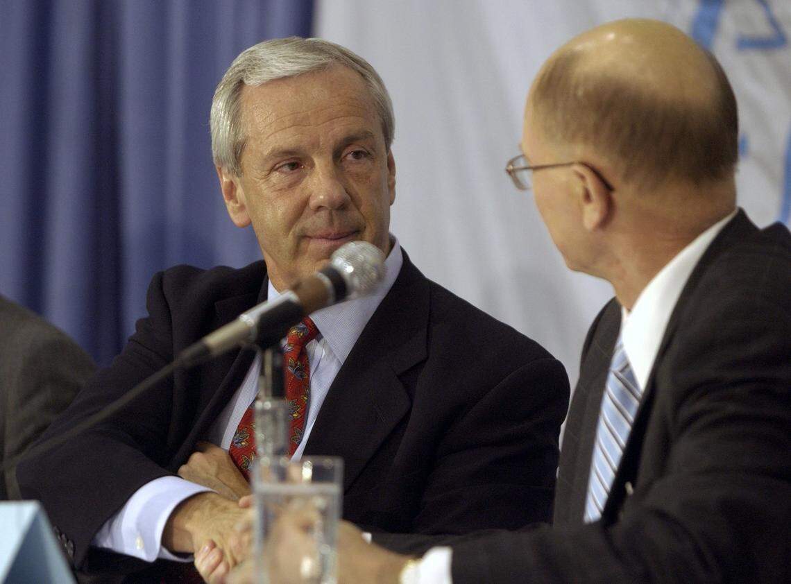 WILLIAMS20.SP.041403.TSS--CHAPEL HILL--New UNC head coach Roy Williams shakes hands with UNC chancellor James Moeser during a press conference announcing Williams’ hiring in the practice gym in the Smith Center, Monday night, April 14, 2003. Staff Photo by Scott Sharpe