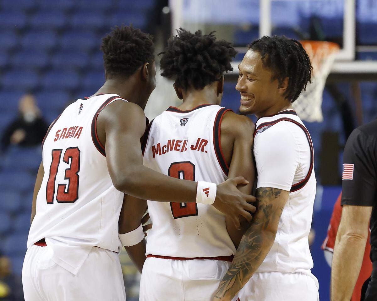N.C. State’s Musa Sagnia and Darrion Williams embrace teammate Paul McNeil Jr. during a timeout in the first half of the Wolfpack’s 76-62 win over Ole Miss on Sunday, Dec. 21, 2025, at First Horizon Coliseum in Greensboro, N.C.