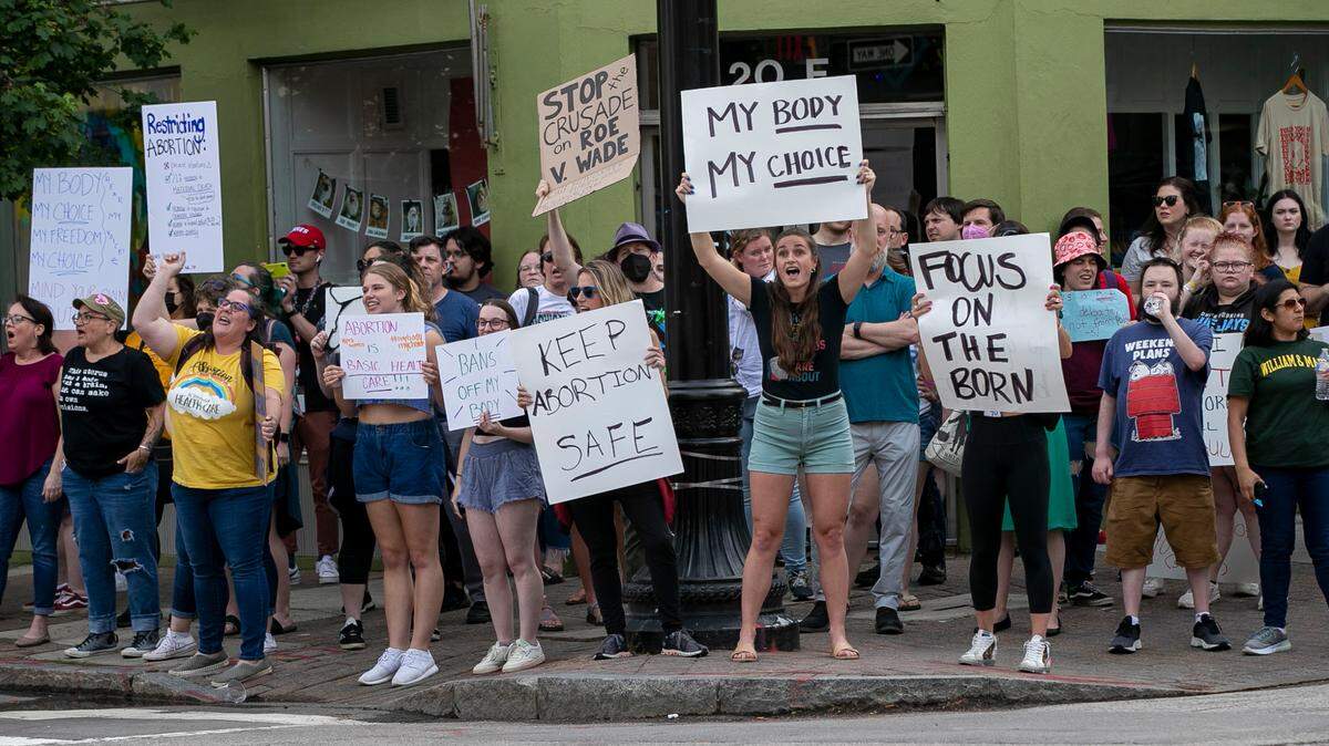 Demonstrators calling for the preservation of abortion rights, react to a draft ruling from the U.S. Supreme Court, that could overturn Roe v. Wade, by gathering on the corner of Hargett and Wilmington Street on Tuesday, May 3, 2022 in Raleigh.