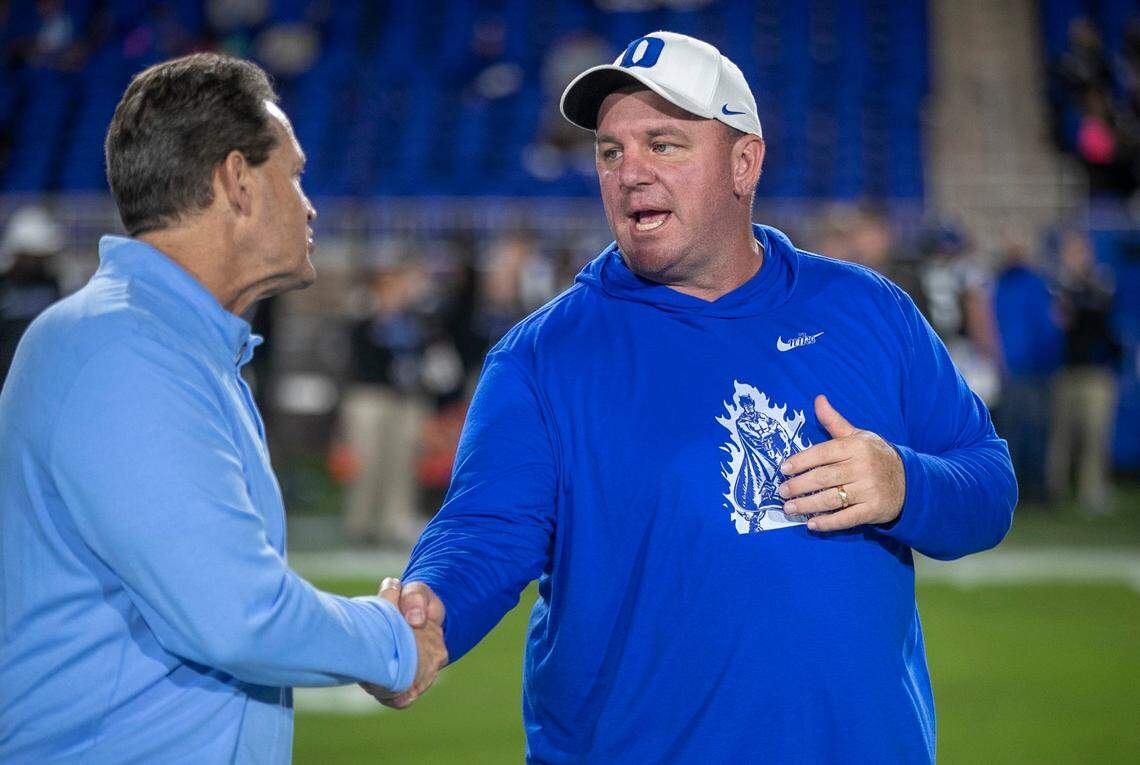 Duke coach Mike Elko talks with North Carolina defensive coach Gene Chizik prior to their game on Saturday, October 15, 2022 at Wallace-Wade Stadium in Durham, N.C.
