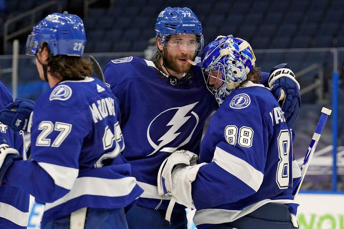 Tampa Bay Lightning goaltender Andrei Vasilevskiy (88) celebrates with defenseman Victor Hedman (77) and defenseman Ryan McDonagh (27) after the team defeated the Carolina Hurricanes during an NHL hockey game Wednesday, Feb. 24, 2021, in Tampa, Fla. (AP Photo/Chris O’Meara)