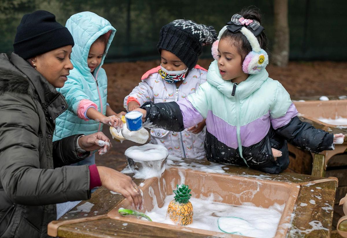 Three-year-old students Ayla Adamas, Zachariah Dunn and Ailani Ramos play with teacher Nikki Pendleton during recess at A Safe Place Child Enrichment Center on Tuesday, December 20, 2022 in Raleigh, N.C
