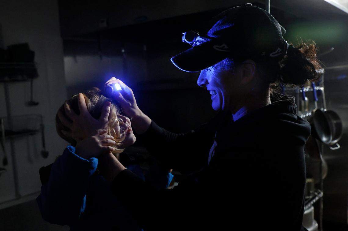 Rachel Haviley, owner of Limitless Meal Supply, helps her son, Emerson, 3, put on a headlamp in the restaurant’s kitchen during a power outage on Monday, Dec. 5, 2022, in Carthage, N.C. Emerson was unable to go to school on Monday due to the power outage.