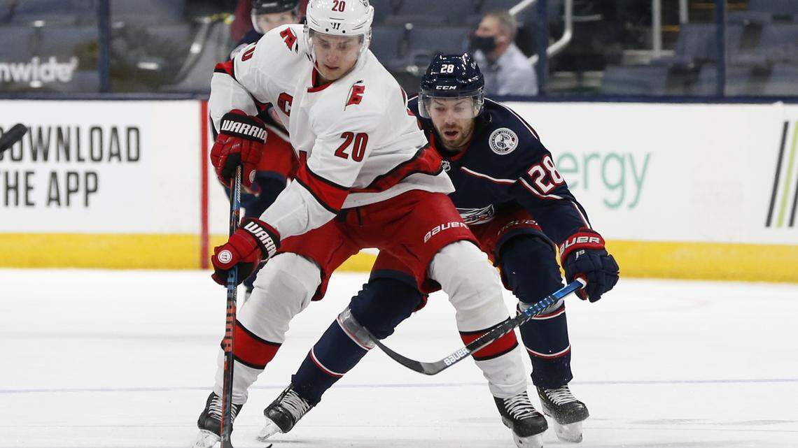 Carolina Hurricanes’ Sebastian Aho, left, carries the puck up ice as Columbus Blue Jackets’ Oliver Bjorkstrand defends during the first period of an NHL hockey game Monday, Feb. 8, 2021, in Columbus, Ohio. (AP Photo/Jay LaPrete)
