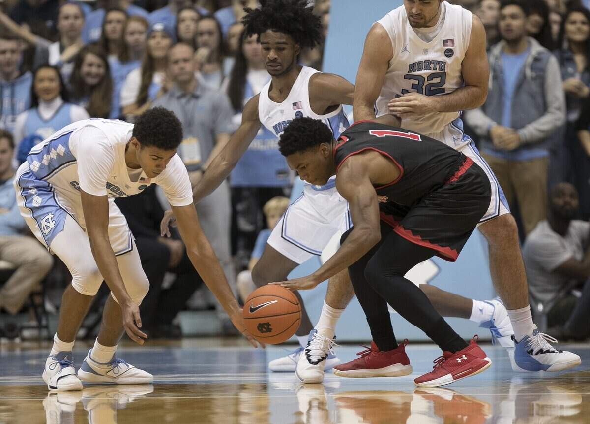 North Carolina’s Cameron Johnson (13) tries for a steal from St. Francis’ Ramir Dixon-Conover (1) during the first half on Monday, November 19, 2018 at the Smith Center in Chapel Hill, N.C.