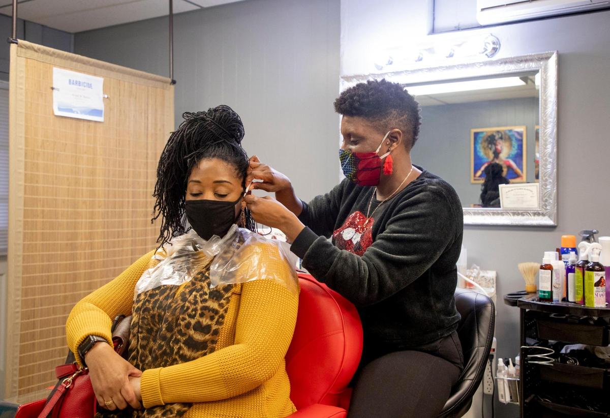 Denise Browning, left, has her Sisterlocks retightened in The Barbee Shop by Wendi Barbee, right, on Friday, Jan. 15, 2021, in Durham, N.C.