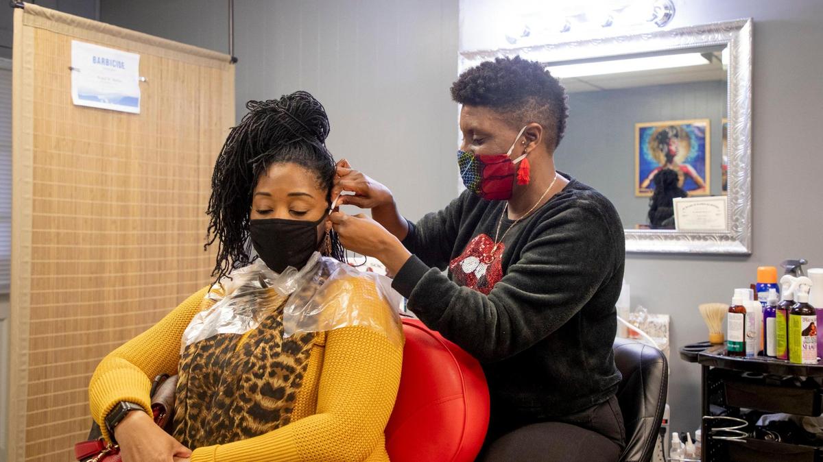 Denise Browning, left, has her Sisterlocks retightened in The Barbee Shop by Wendi Barbee, right, on Friday, Jan. 15, 2021, in Durham, N.C.