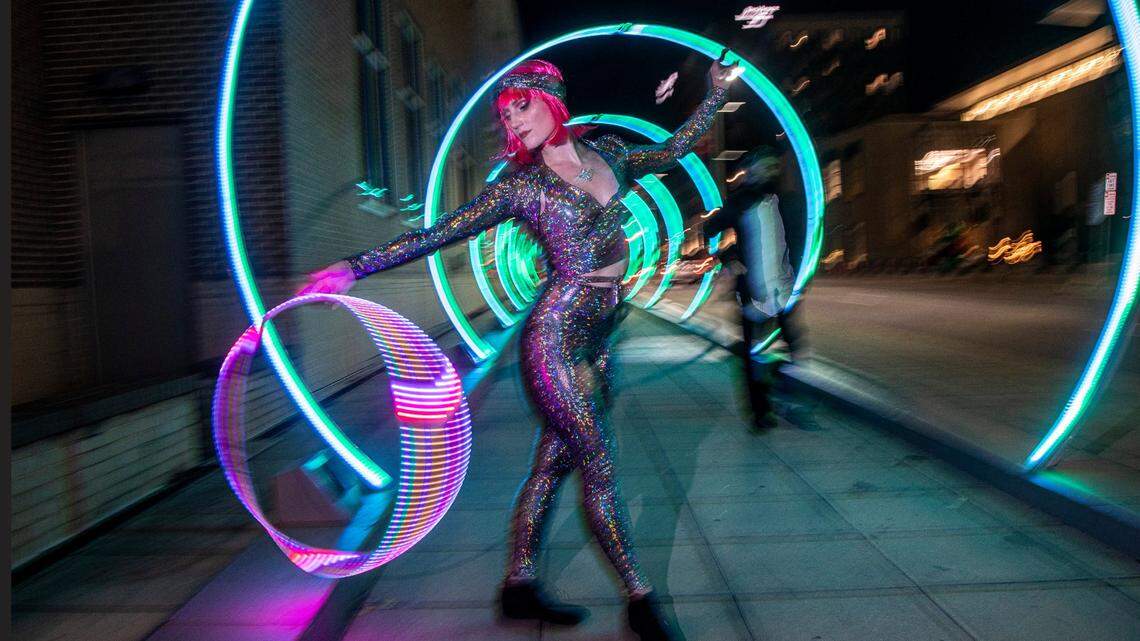 Hoop dancer Paige LaWall performs in the “Sonic Runway” along South Saunders Street in downtown Raleigh Friday, Dec. 2, 2022. The large-scale, interactive light-based art piece is one of 18 installations around downtown Raleigh and the Glenwood South district that make up the Illuminate Art Walk presented by Wake Tech.