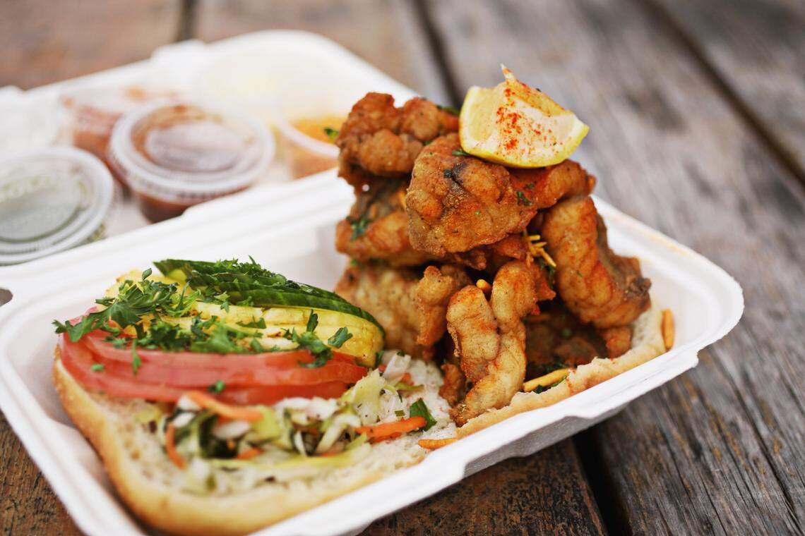 An open faced sandwich made with a fried savory doughnut and marinated dogfish, served with lettuce, tomato, pineapple and a cilantro sauce.