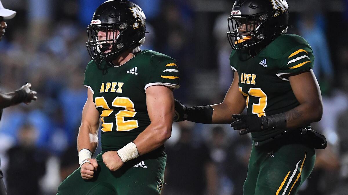 Apex’s Ian Bright (22) and Da’Shawn Haney (23) celebrate after Bright’s defensive stop in overtime. The Apex Cougars and the Panther Creek Catamounts met in a NCHSAA 4A 1st round football playoff game in Apex, NC on November 4, 2022.