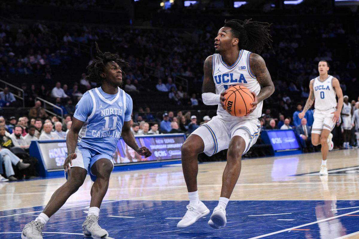 UCLA Bruins guard Sebastian Mack (12) drives to the basket while being defended by North Carolina Tar Heels guard Ian Jackson (11) during the first half at Madison Square Garden.