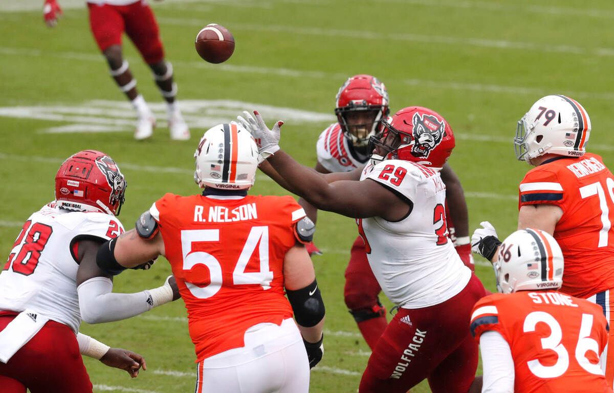 N.C. State defensive tackle Alim McNeill (29) keeps his eye on the ball while making an interception during the second half of N.C. State’s 38-21 victory over Virginia at Scott Stadium in Charlottesville, Va., Saturday, Oct. 10, 2020.