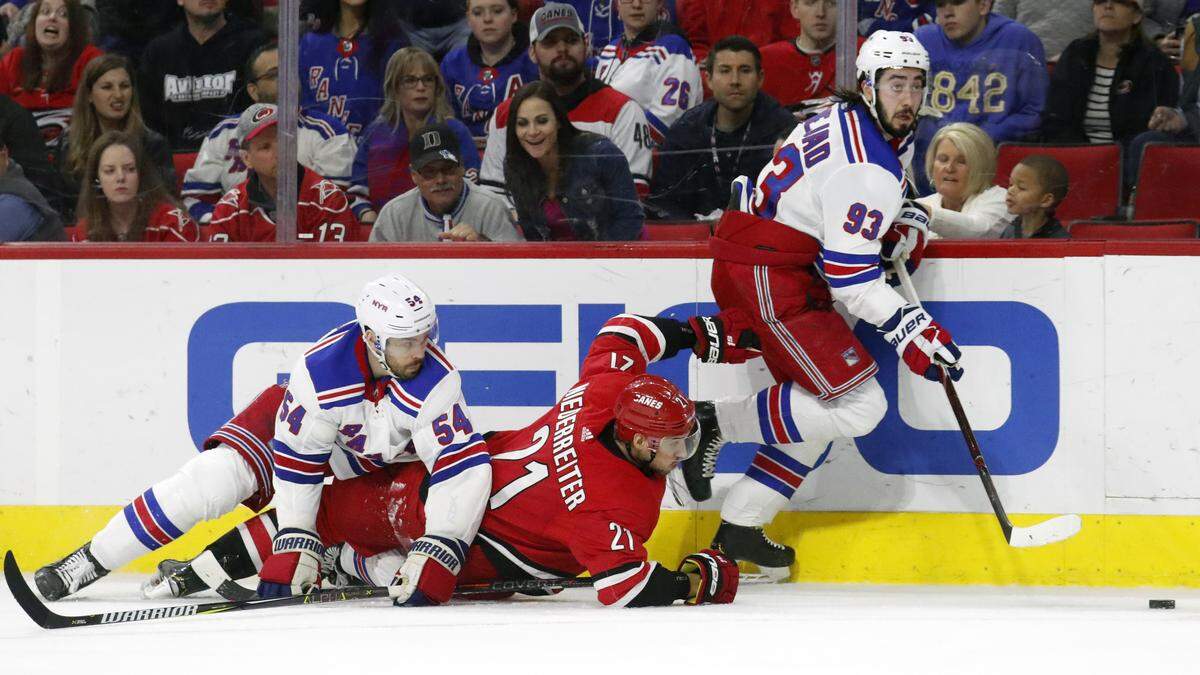 Carolina Hurricanes’ Nino Niederreiter (21) of Switzerland battles the New York Rangers’ Adam McQuaid (54) and Mika Zibanejad (93) of Sweden for the puck during the second period of an NHL hockey game in Raleigh, N.C., Tuesday, Feb. 19, 2019.