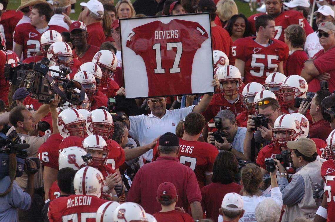 N.C. State head coach Chuck Amato holds Philip Rivers’ retired jersey aloft as Rivers makes his way through a throng of teammates Saturday before the Wolfpack final game of the regular season against Maryland in Sept. 2003. Rivers is only the eighth player at State to have his jersey retired.