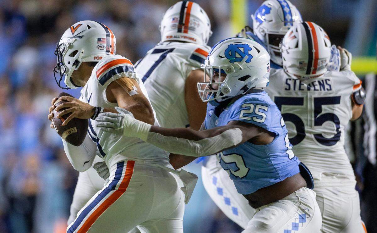 North Carolina’s Kaimon Rucker (25) pressures Virginia quarterback Tony Musket (11) in the first quarter on Saturday, October 21, 2023 at Kenan Stadium in Chapel Hill, N.C.