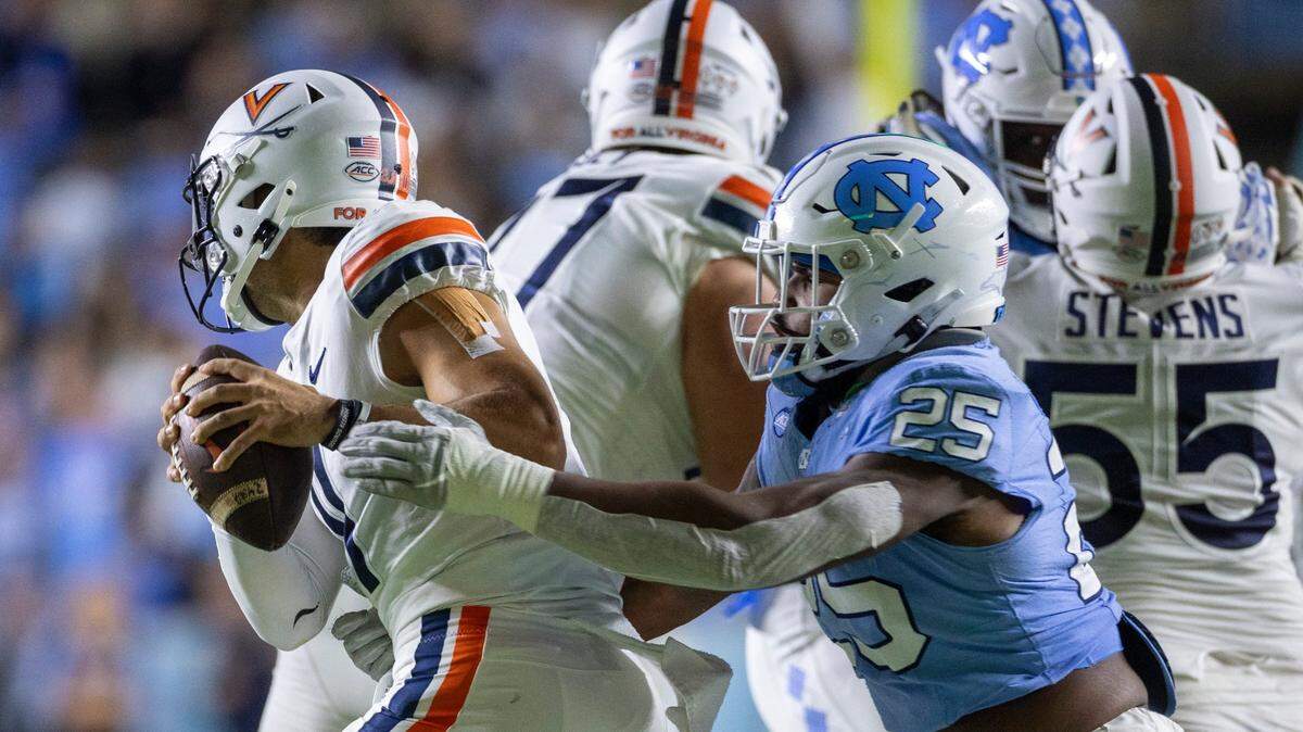 North Carolina’s Kaimon Rucker (25) pressures Virginia quarterback Tony Musket (11) in the first quarter on Saturday, October 21, 2023 at Kenan Stadium in Chapel Hill, N.C.