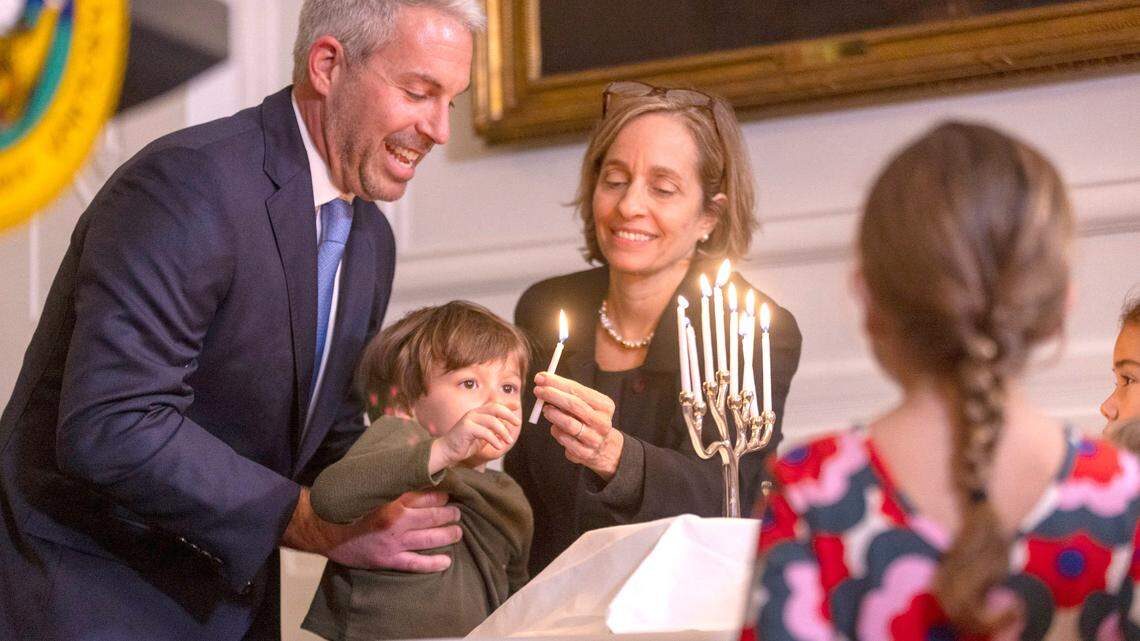 Rabbi Eric Solomon, from Beth Meyer Synagogue in Raleigh, and Rabbi Judy Schindler of Charlotte, assist four-year-old Benny Wineburg with the lighting of the Menorah during a gathering with the North Carolina Jewish Clergy Association on Wednesday, December 14, 2022 at the Executive Mansion in Raleigh, N.C. The Governor opted to have the lighting inside due to weather. First Lady Kristin Cooper said a giant Menorah will be illuminated on the front lawn of the mansion, and that it is so large: “It’s visible from space’.