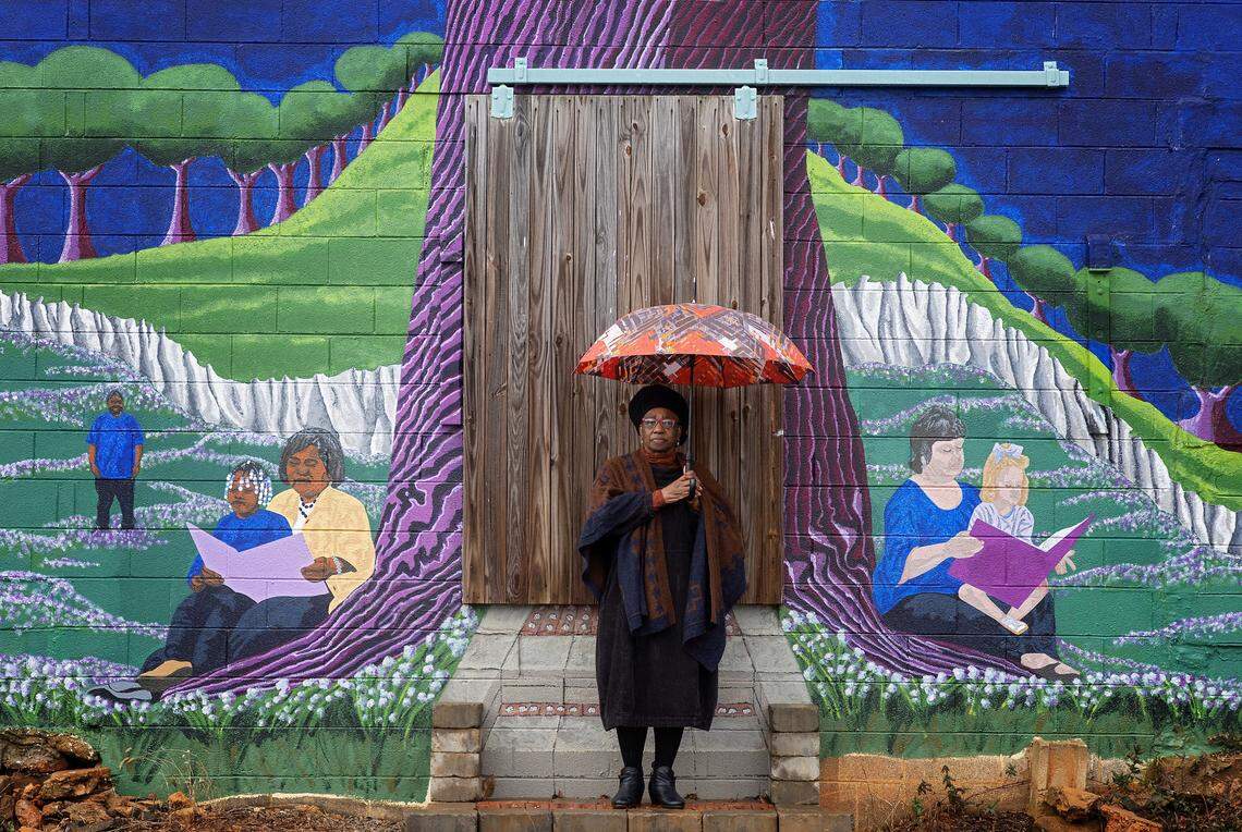 Jereann Johnson stands next to a mural in Warrenton on Feb. 2. Johnson, who grew up in southwest Georgia, says her parents did not have a copy of the Green Book, but knew by word of mouth where to go when traveling. The Green Book, published from 1936 to 1966, listed motels, restaurants and other businesses where Black travelers were safe to stop.