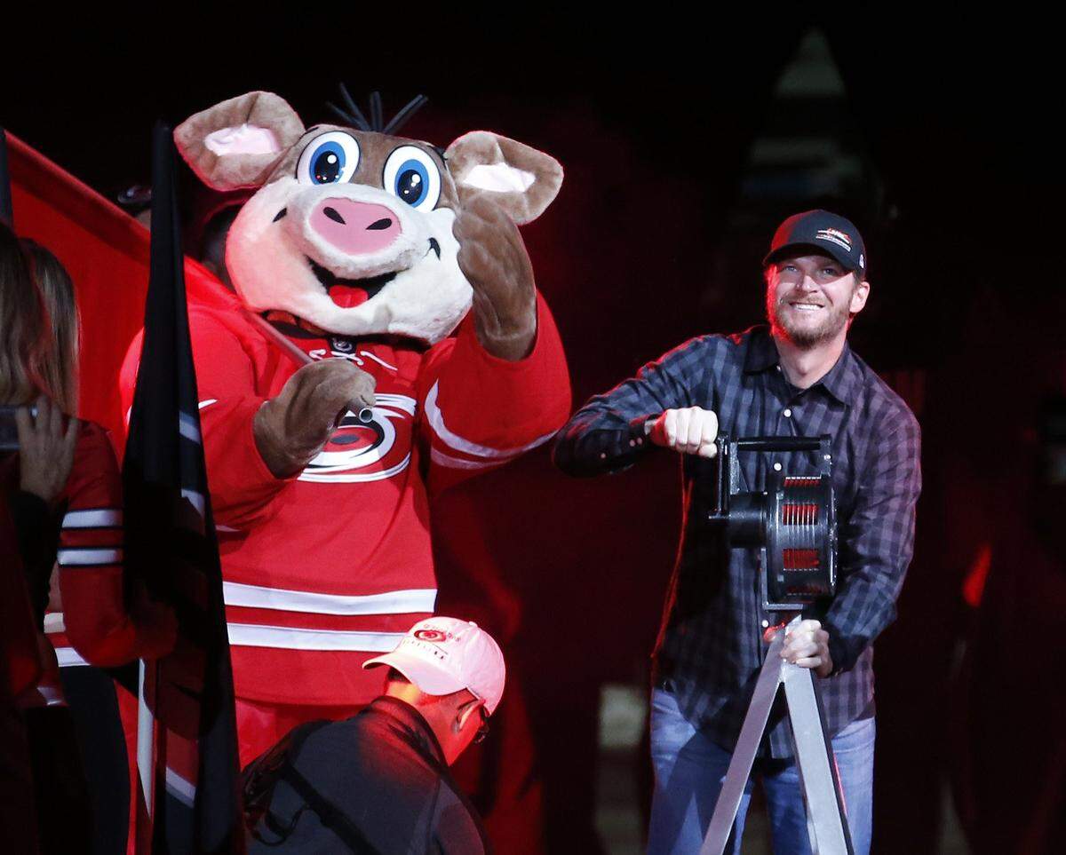 NASCAR star Dale Earnhardt Jr. sounds the siren at the start an NHL game played between the Carolina Hurricanes and the New York Rangers at PNC Arena in October 2016.