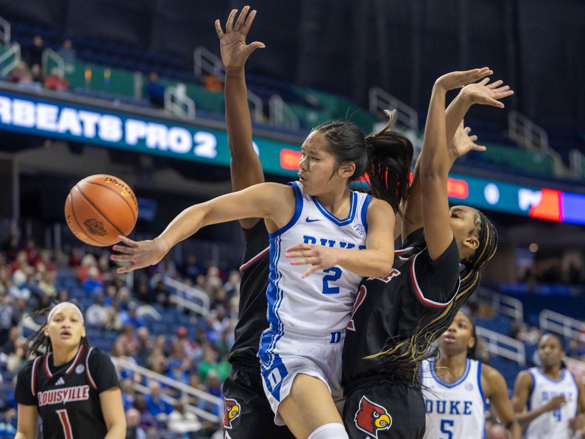 Duke’s Vanessa de Jesus (02) passes out of a trap by Louisville’s Olivia Cochran (44) and Tajianna Roberts (22) in the second half on Friday, March 7, 2024 during the quarterfinals of the ACC Women’s Tournament in Greensboro, N.C.