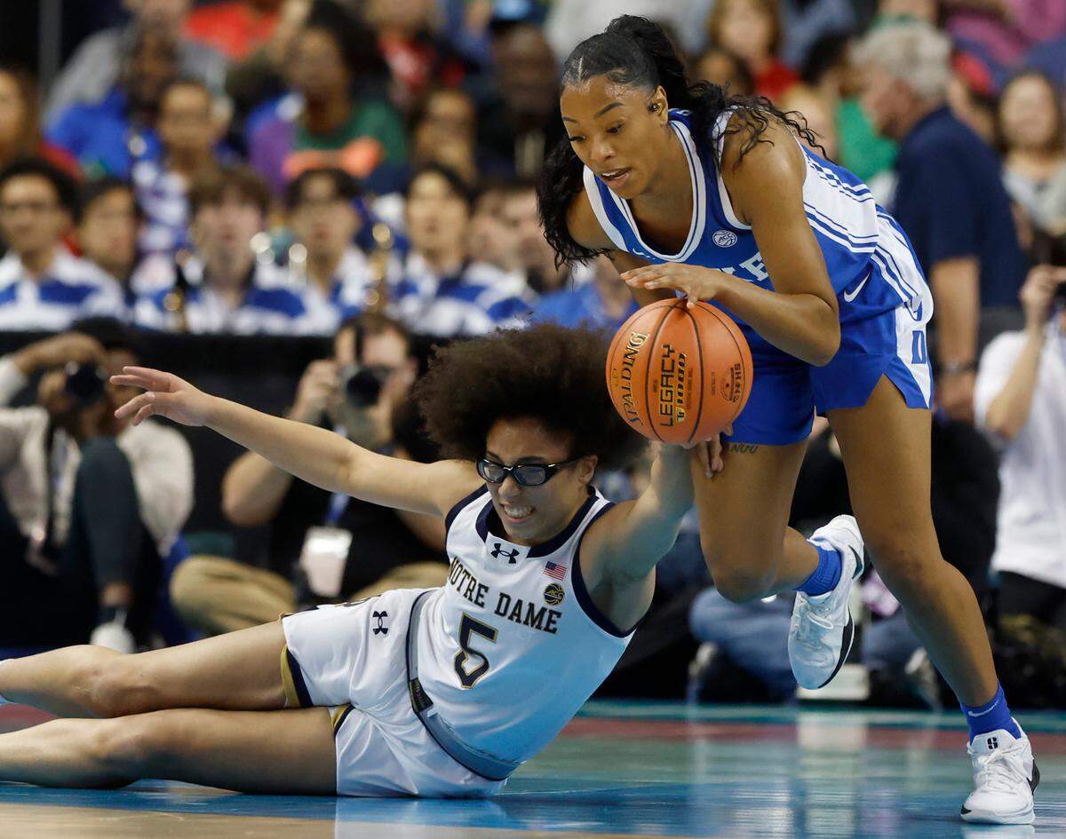 Notre Dame’s Olivia Miles and Duke’s Reigan Richardson dive after a loose ball during the first half of the Blue Devils’ 61-56 ACC Tournament semifinal win on Saturday, March 8, 2025, at First Horizon Coliseum in Greensboro, N.C.