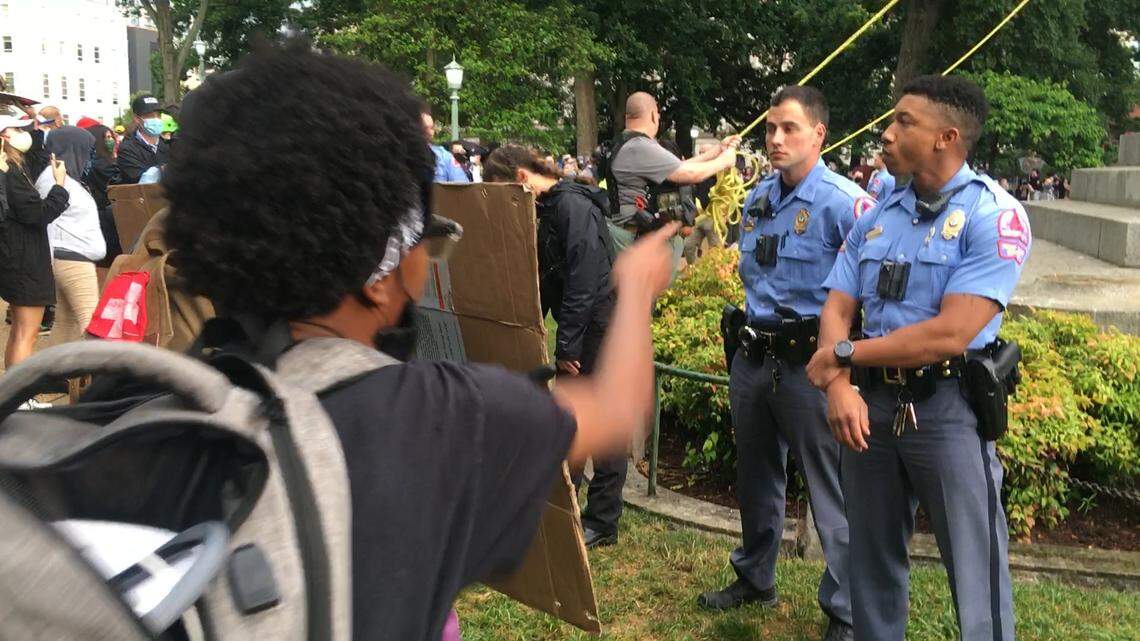 A protester shouts at Raleigh Police officers at the Confederate monument on the grounds of the State Capitol Friday evening, June 19, 2020.