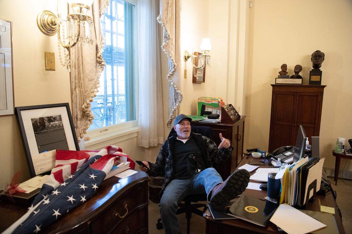 A supporter of U.S. President Donald Trump sits inside the office of U.S. Speaker of the House Nancy Pelosi as he protests inside the U.S. Capitol in Washington, D.C., on Wednesday, Jan. 6, 2021. Demonstrators breeched security and entered the Capitol as Congress debated the a 2020 presidential election Electoral Vote Certification.