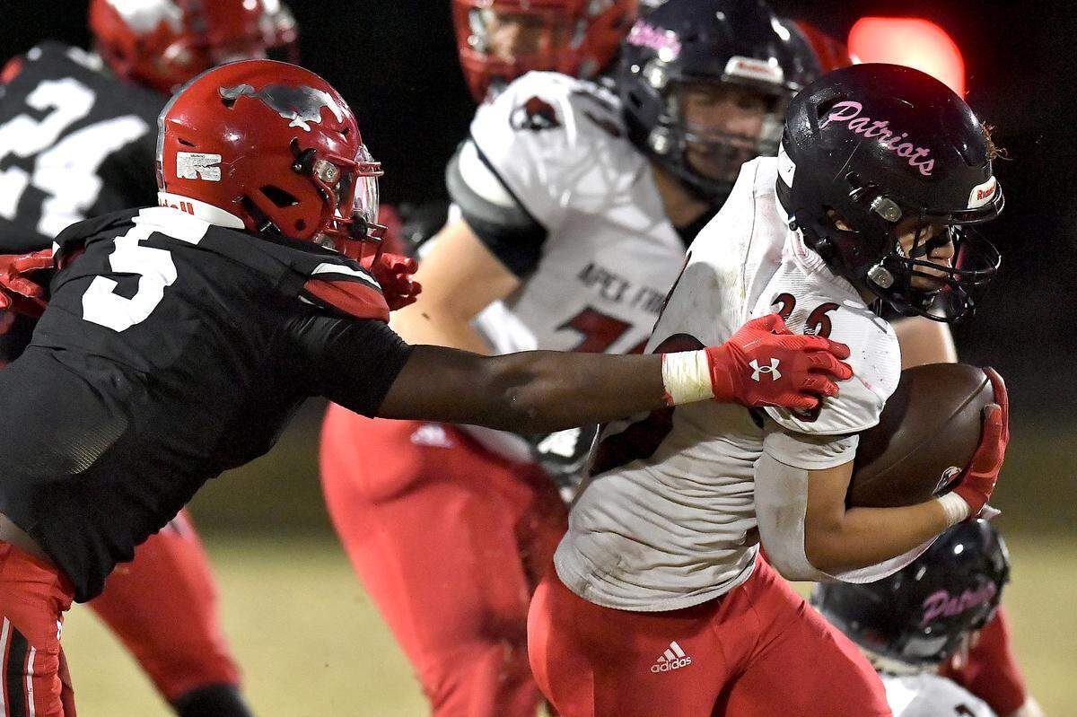 Apex Friendship running back Jaden Avery (26) runs for yards against Middle Creek cornerback Christian Prince (5) during the first half. The Middle Creek Mustangs and the Apex Friendship Patriots met in a football game in Cary, N.C. on October 25, 2024. The Middle Creek Mustangs and the Apex Friendship Patriots met in a football game in Cary, N.C. on October 25, 2024.