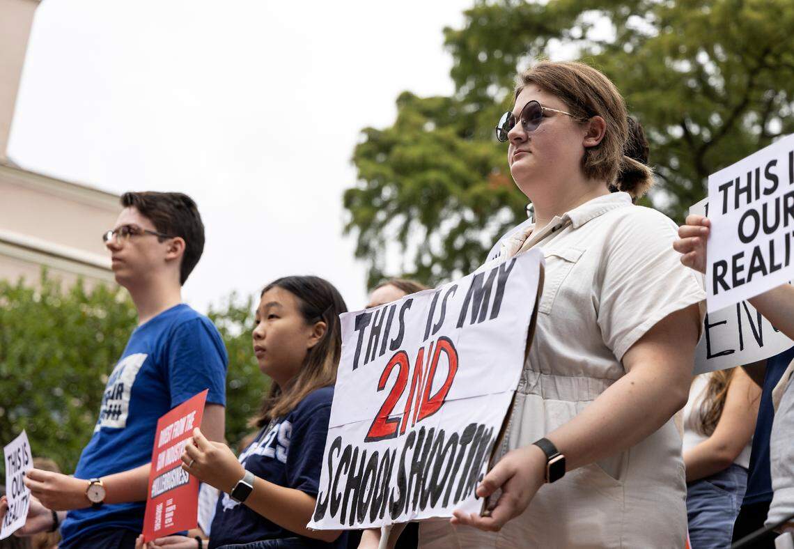 Danielle Kennedy, right, holds a sign during a student-led rally at UNC-Chapel Hill in support of gun control on Wednesday, Aug. 30, 2023. A graduate student has been charged with first-degree murder following a Monday shooting that left a faculty member dead on the campus.