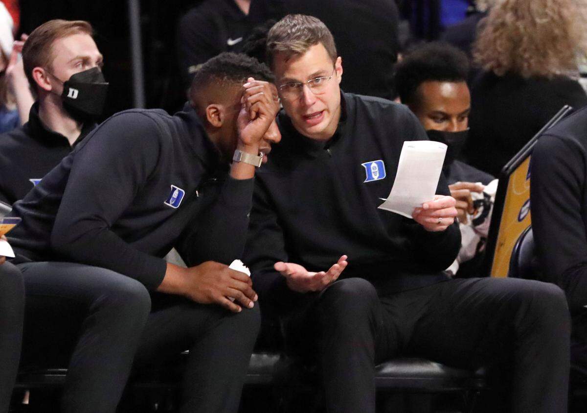 Duke associate head coach Jon Scheyer talks with assistant coach Nolan Smith during Duke’s 76-64 victory over Wake Forest at LJVM Coliseum in Winston-Salem, N.C., Wednesday, January 12, 2022.