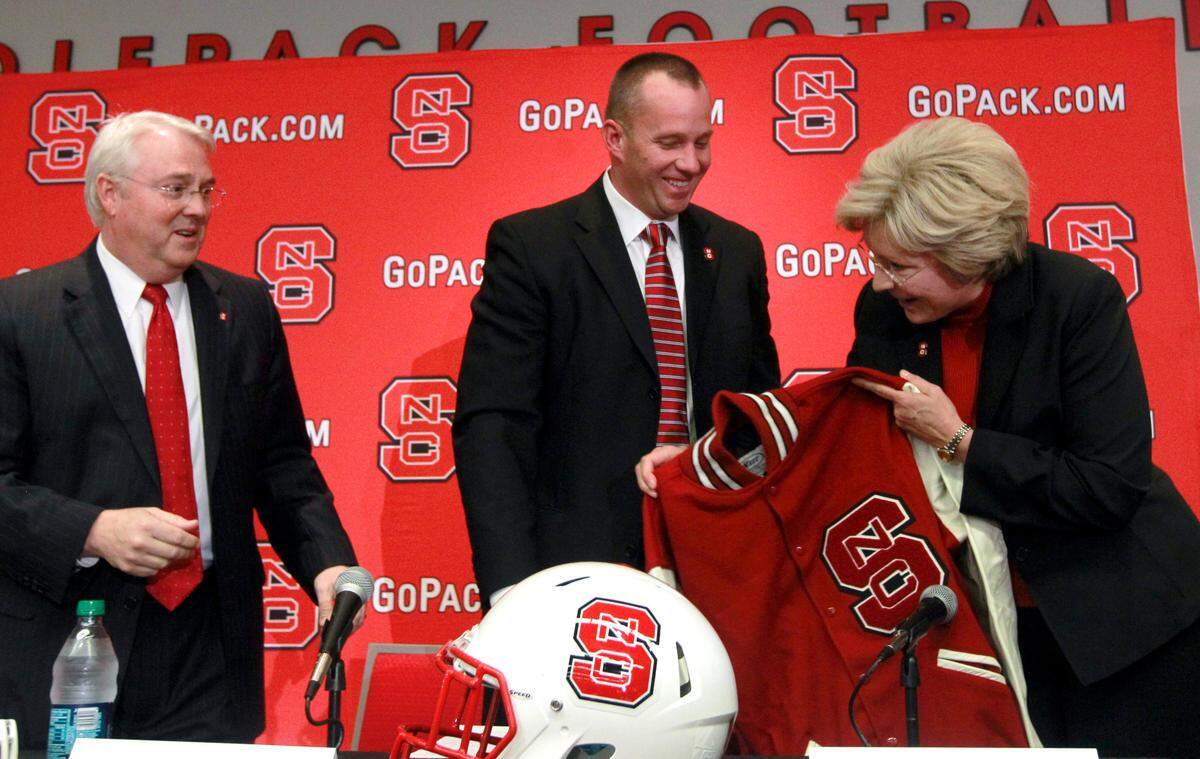 Dave Doeren, center, laughs with athletic director Debbie Yow as he gets a letterman’s jacket during a press conference where Doeren was introduced as N.C. State’s new head football coach Sunday, December 2, 2012, at the Wendell H. Murphy Football Center in Raleigh, N.C. Chancellor Randy Woodson is to the left.