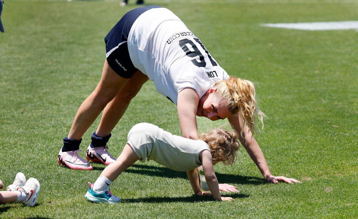 US Women’s Allie Long (16) stretches with her daughter, Max, 2, after Streetball FC Canada’s 3-0 victory over the US Women during the TST Soccer Tournament at WakeMed Soccer Park in Cary, N.C., Friday, June 7, 2024.