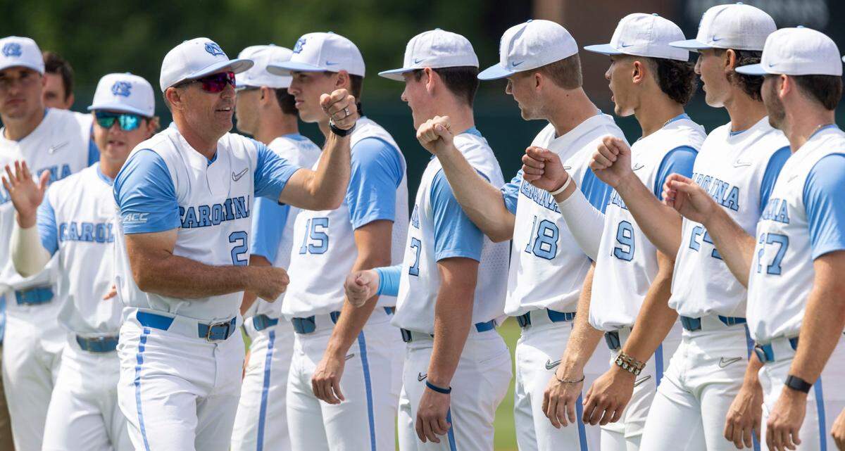 North Carolina coach Scott Forbes fist bumps his players as he is introduced prior to the Tar Heels game against Arkansas on Saturday, June 11, 2022 at Boshamer Stadium in Chapel Hill, N.C.